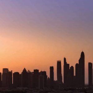 Silhouette of a city skyline at sunset with tall buildings