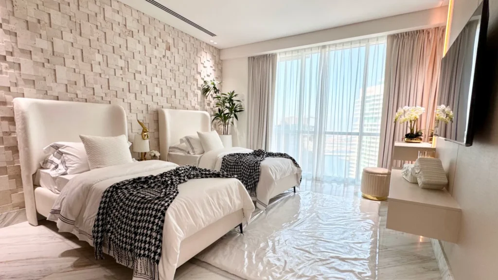 Twin beds and window with curtains in bedroom at Al Fattan Marine Towers Dubai Marina Dubai