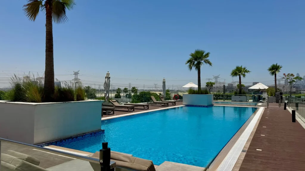 Бассейн на открытом воздухе с шезлонгами в комплексе Azizi Riviera 13 в районе Meydan Дубая