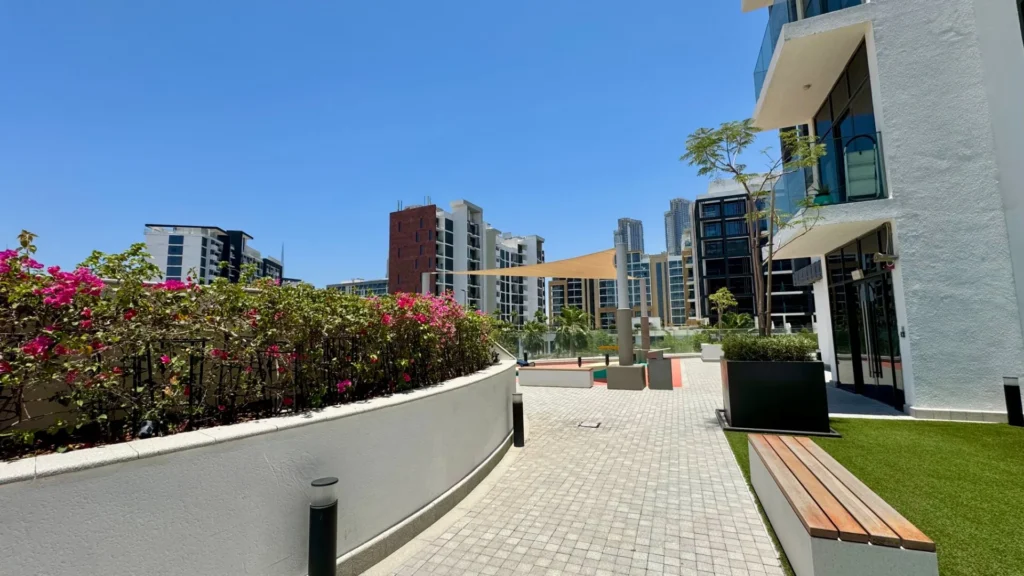 Прогулочная зона с цветами и скамейками в Azizi Riviera 13 в районе Meydan Дубая