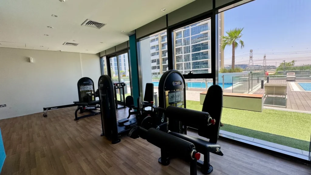 Тренажерный зал с видом на бассейн в Azizi Riviera 13 районе Meydan Дубай