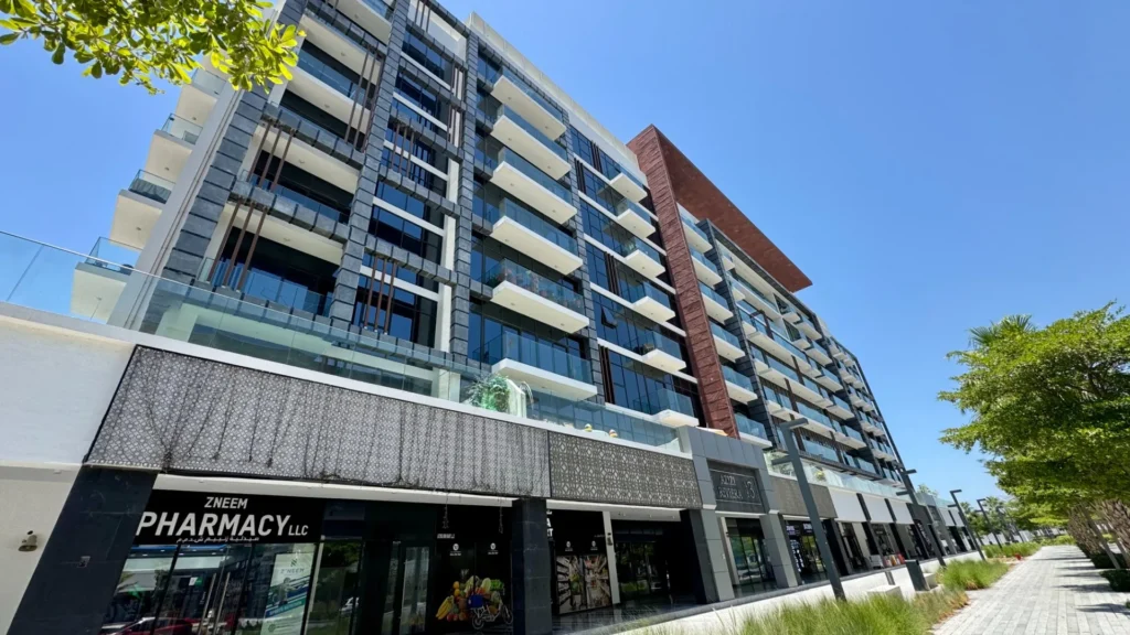Фасад жилого комплекса Azizi Riviera 13 в районе Мейдан Дубай с магазинами на первом этаже