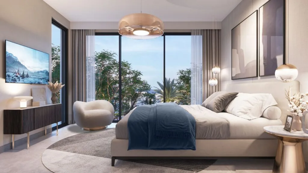Bedroom interior with large bed and balcony view of trees