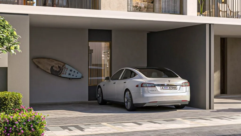 White car parked in fully covered parking space with surfboard on wall