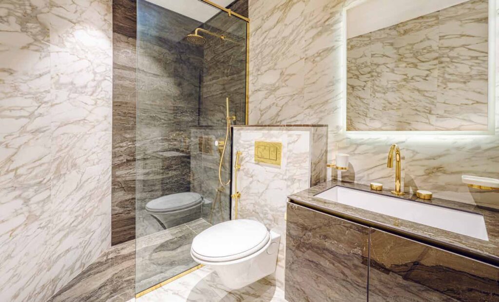 Bathroom interior with marble walls and gold fixtures