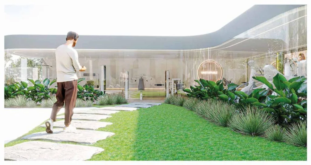 Man walking on stone path towards glass building with plants