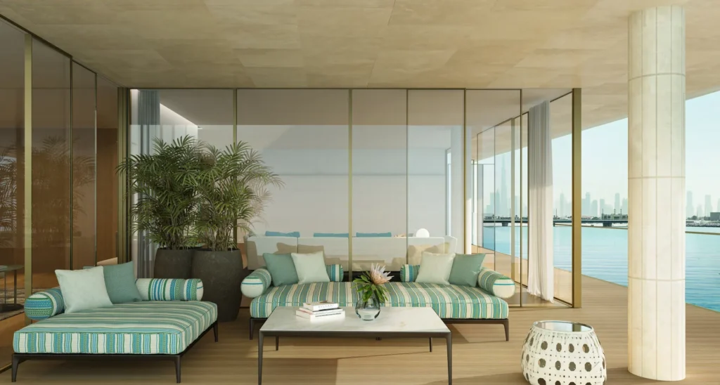 Open-plan lounge with striped sofas and wide glass walls overlooking the water (developer rendering)