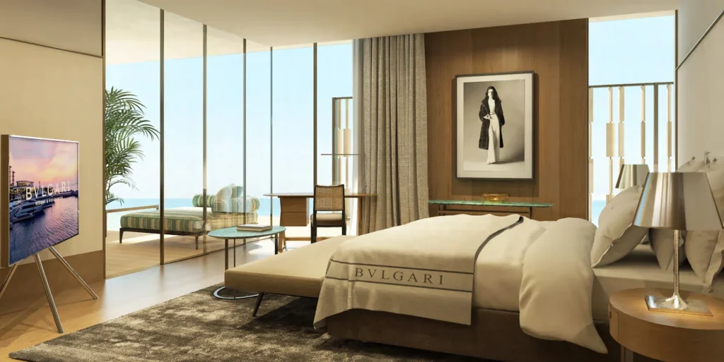 Master bedroom with Bulgari-branded bed, wood panelling and waterfront view (developer rendering)