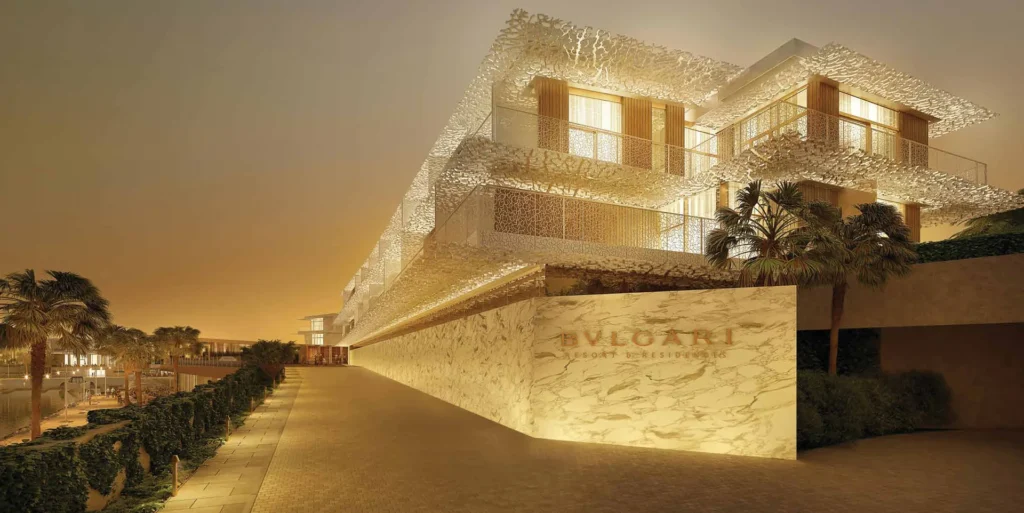Bulgari Resort and Residences facade with perforated screen balconies glowing at dusk (developer rendering)