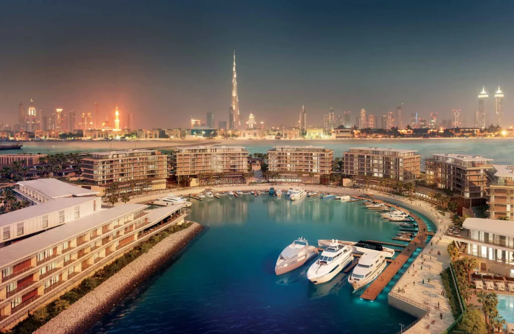 Marina at Bulgari Resort and Residences with moored yachts and Dubai skyline at night (developer rendering)