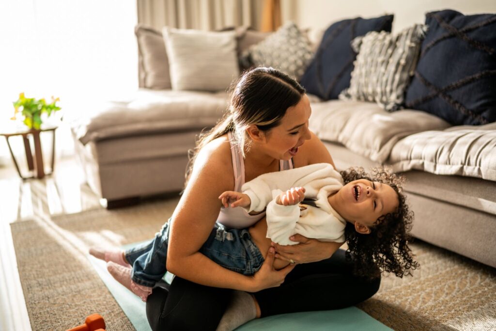 Woman playing with child on floor in living room