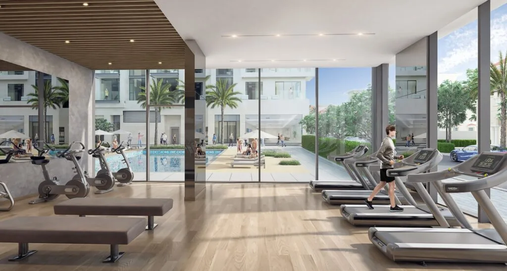 Gym interior with exercise bikes and treadmills overlooking pool