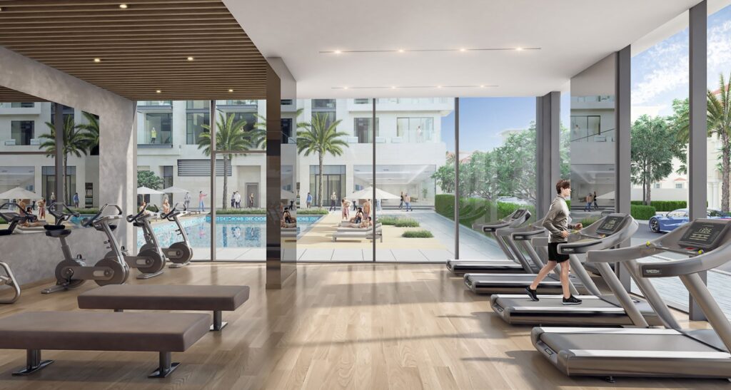 Gym interior with exercise bikes and treadmills overlooking pool