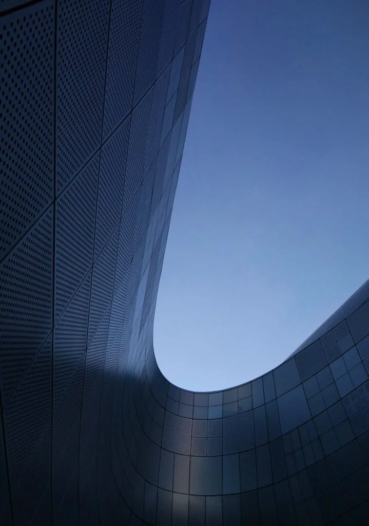 curved modern building facade under clear blue sky
