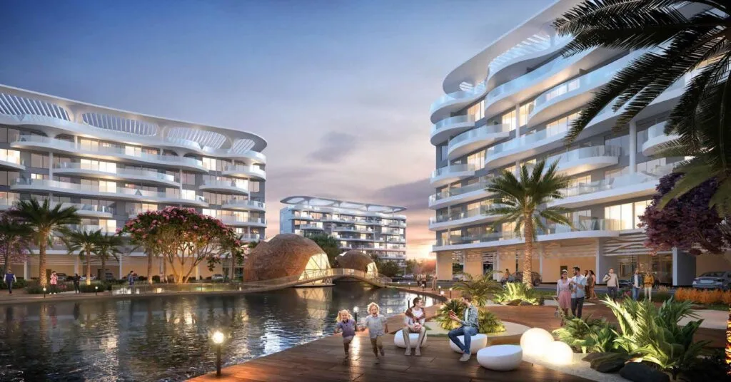 Exterior view of modern apartment buildings by water with palm trees