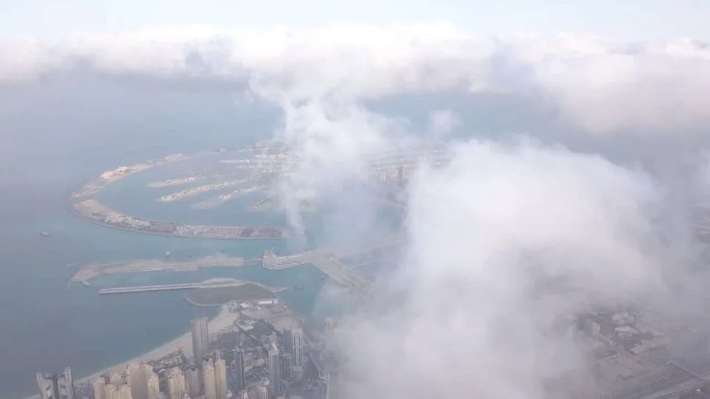 Aerial view of The Palm and Dubai skyline in fog