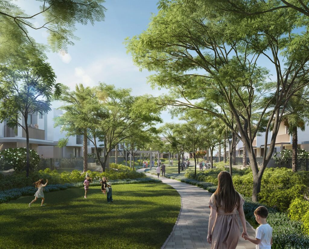 Pathway through green park area with trees and residential buildings