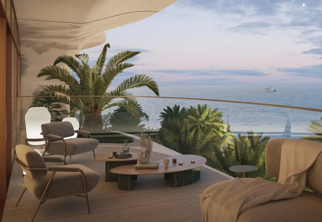 Balcony seating area overlooking ocean and palm trees