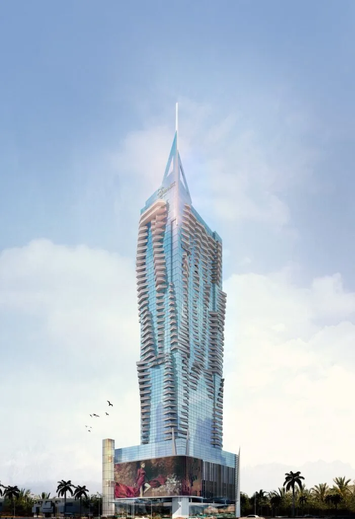 Tall modern glass skyscraper with balconies and spire