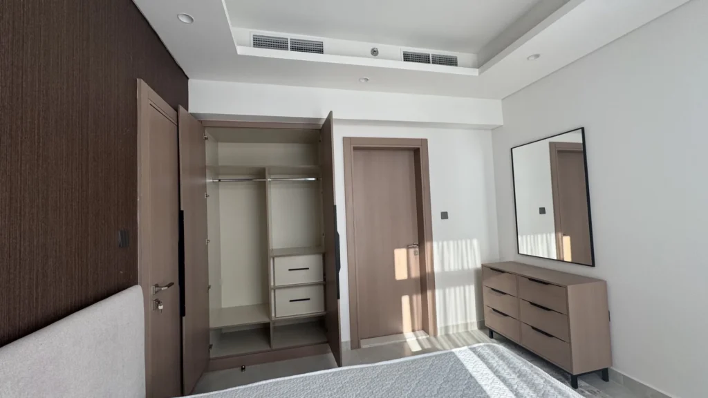 Спальня с открытым шкафом и комодом в апартаментах Cloud Towers Jumeirah Village Triangle