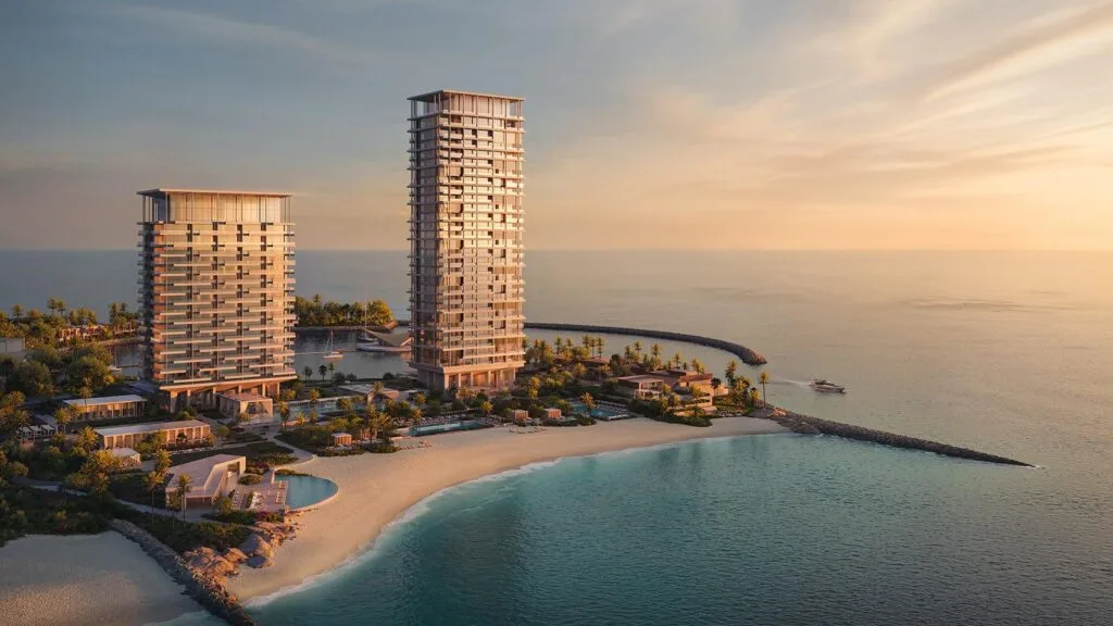 Two residential towers on beachfront with surrounding water and beach