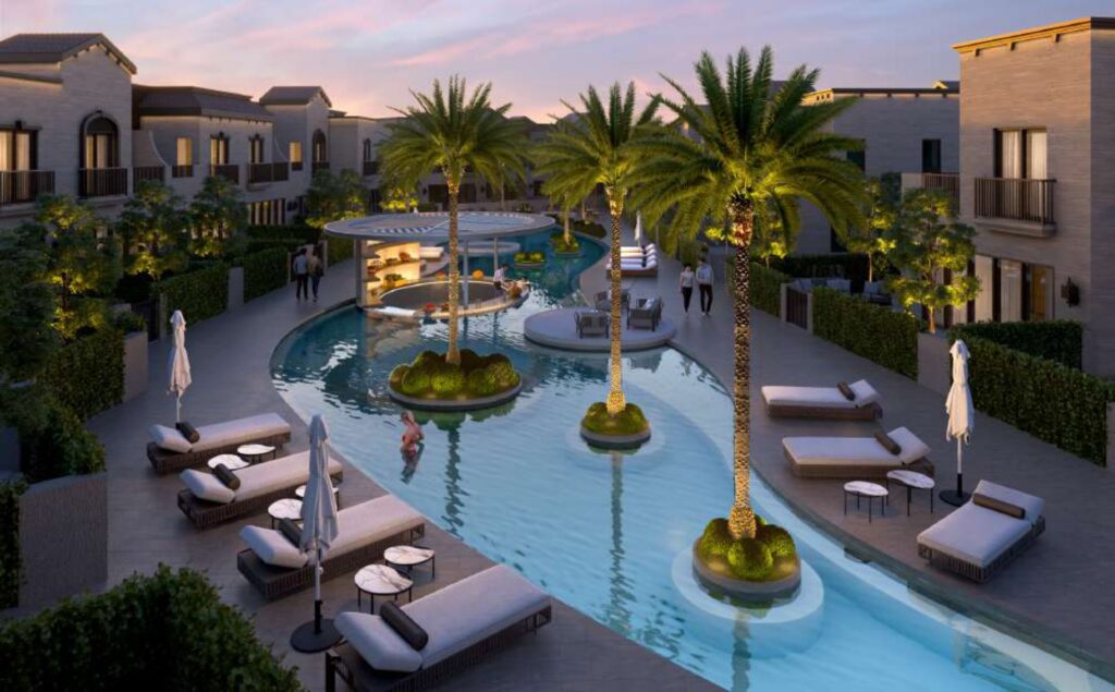 Outdoor pool area with palm trees and sun loungers between residential buildings