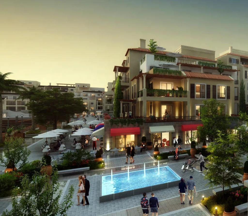 Evening plaza with fountain and shops beneath Port de La Mer apartment buildings (developer rendering)