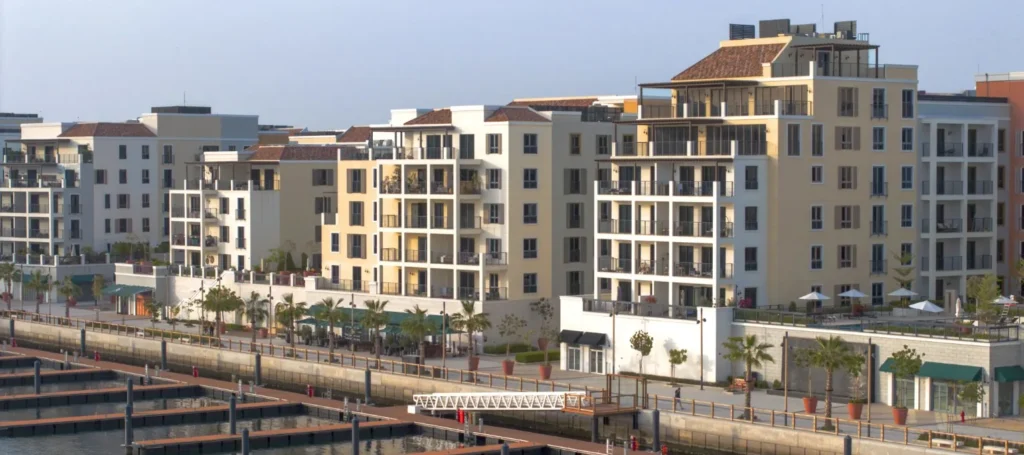 La Rive apartment facades with balconies above the marina docks at Port de La Mer (developer rendering)