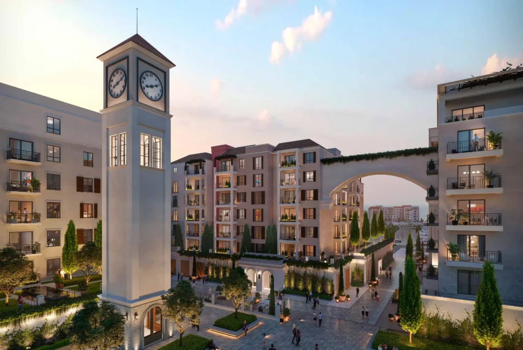 Clock tower and arched passage between La Sirene apartment buildings at dusk (developer rendering)