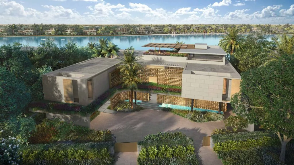 Modern estate building surrounded by greenery near a large lagoon