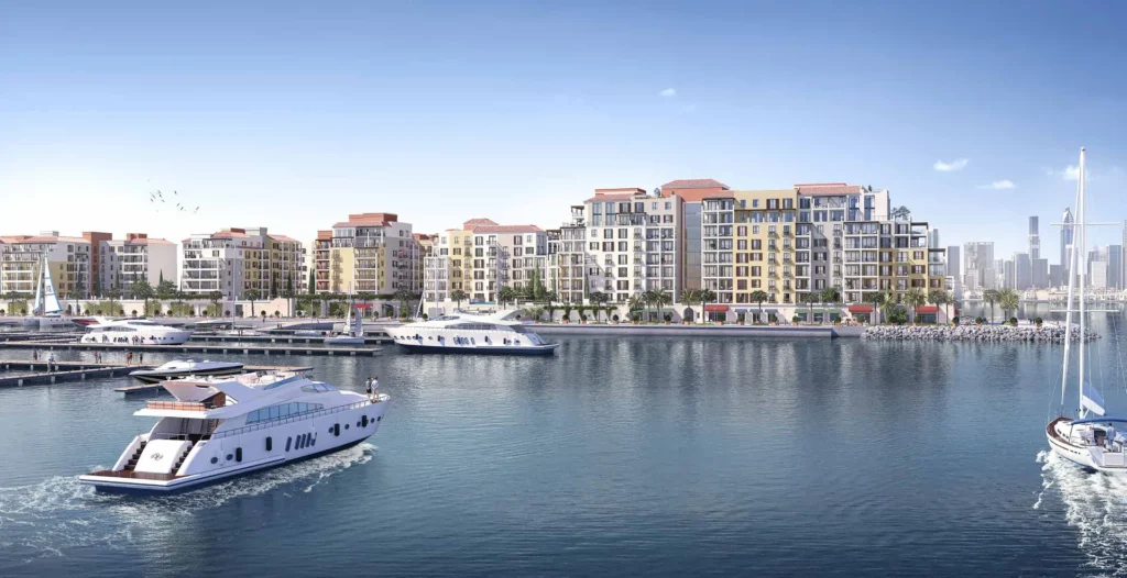 Yacht cruising past Port de La Mer waterfront apartment buildings (developer rendering)