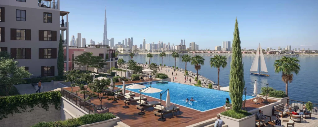 Rooftop pool terrace with sun loungers beside the marina and Dubai skyline (developer rendering)