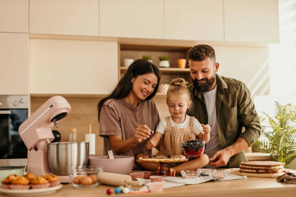 Family preparing food in a kitchen with dining area