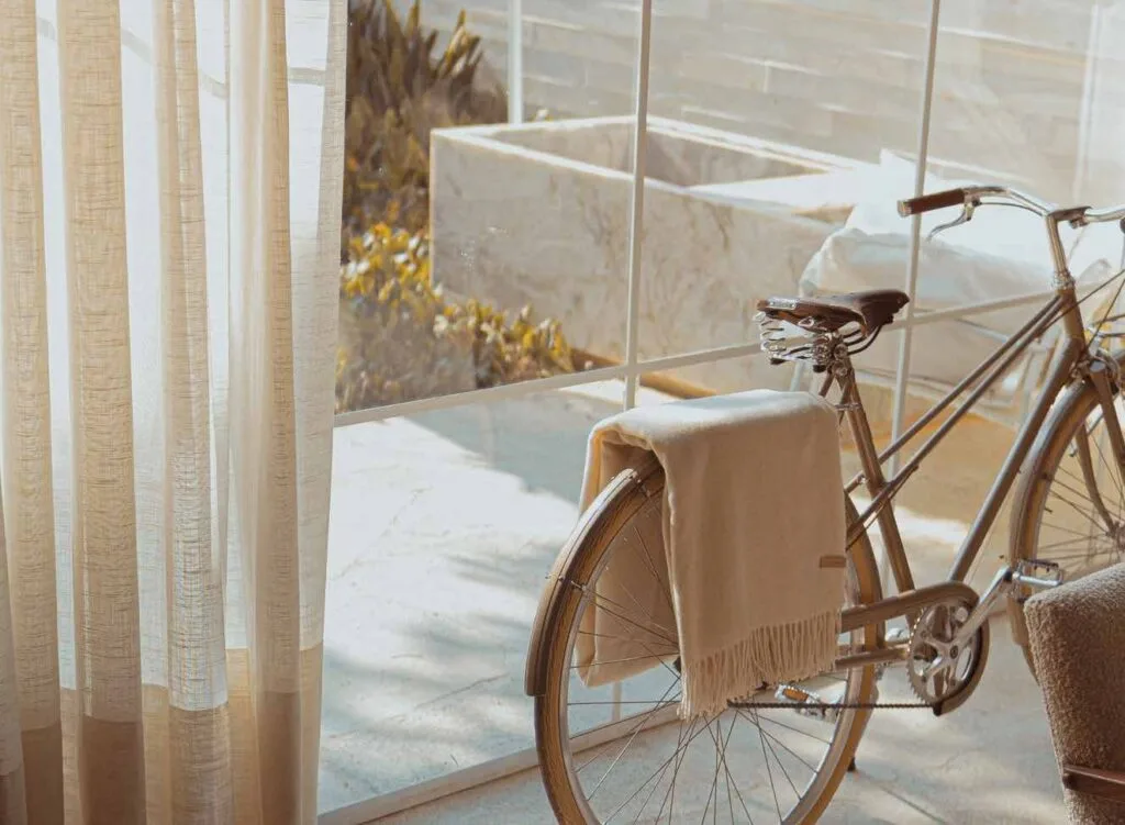 Bicycle with blanket near window and curtains inside room