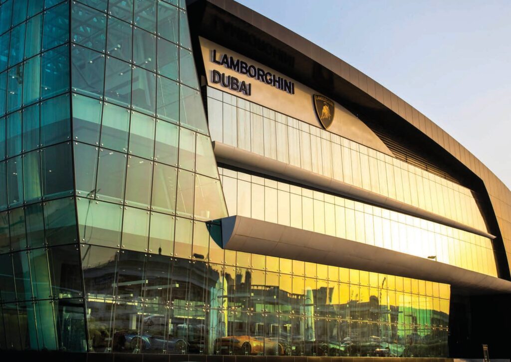 Exterior glass facade of Lamborghini Dubai building at sunset