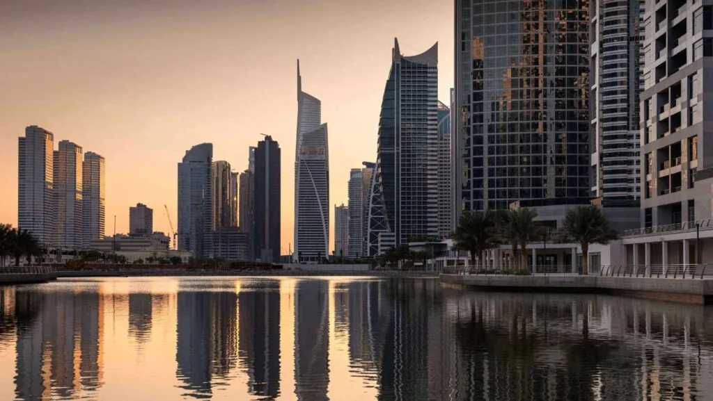 Waterfront view of high-rise buildings at sunset with digital icons