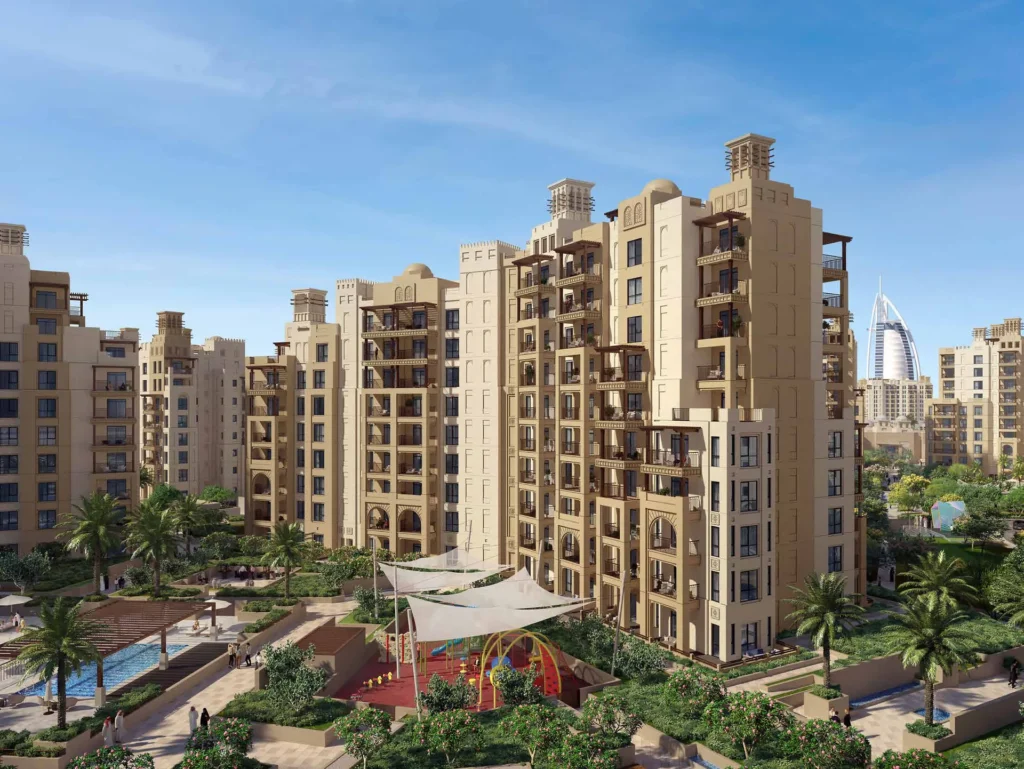 Aerial view of Al Jazi sand-coloured apartment buildings with gardens and Burj Al Arab in the distance (developer rendering)