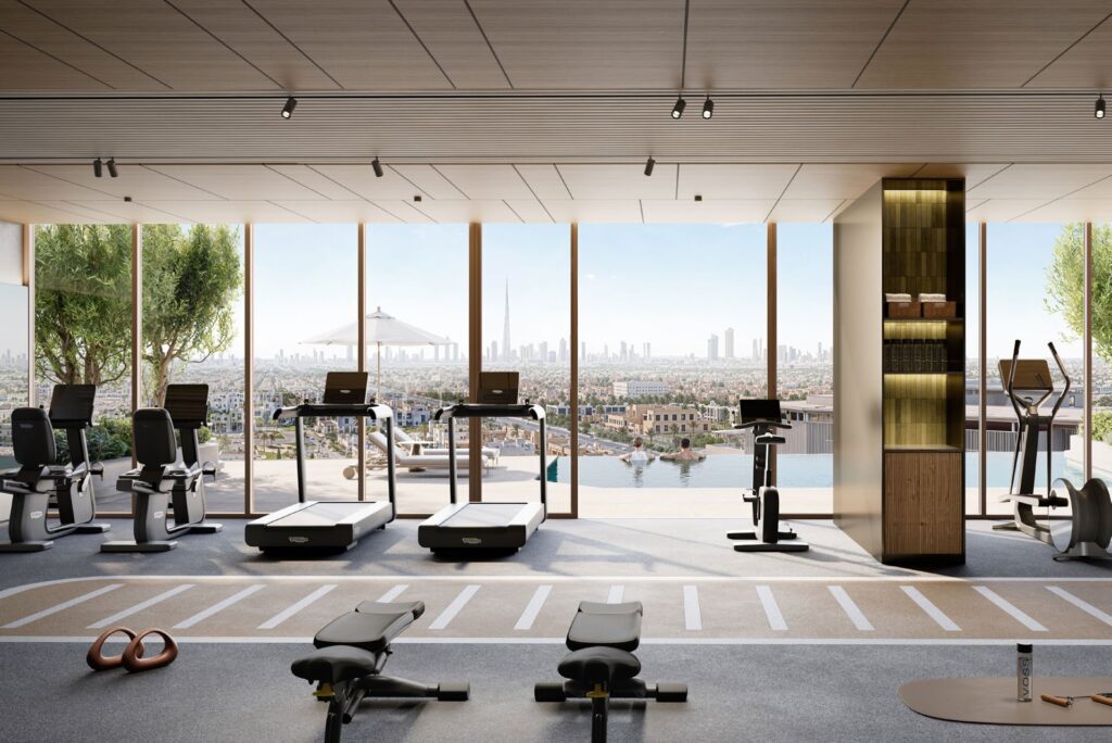 Indoor gym with exercise machines and city view through large windows