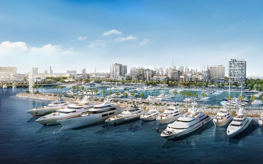 Marina with yachts and waterfront buildings under clear sky