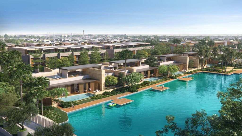 Exterior view of water bungalows by a large pool with greenery