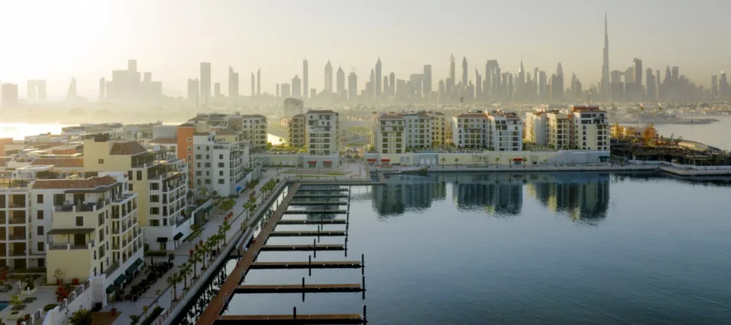 Port de La Mer marina with floating docks and residential buildings reflected in calm water (developer rendering)