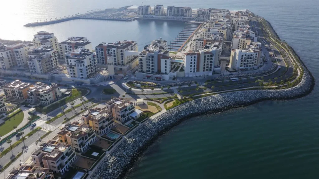 Aerial view of the Port de La Mer island with marina and residential buildings along the breakwater (developer rendering)
