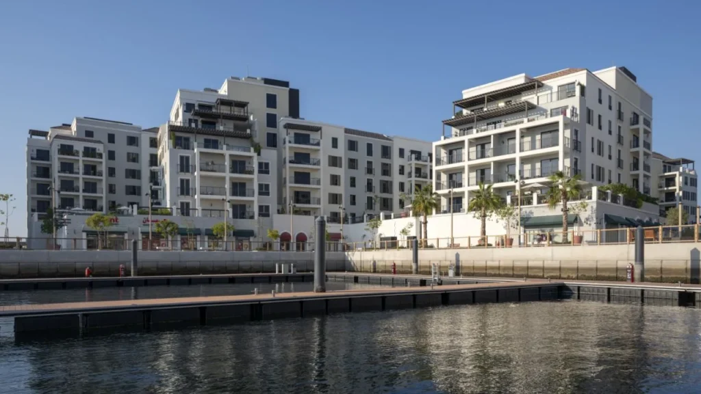 Port de La Mer apartment buildings on the marina waterfront with floating docks (developer rendering)