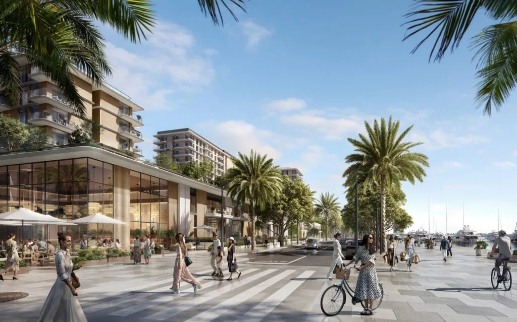 Street view with buildings, palm trees, and waterfront promenade