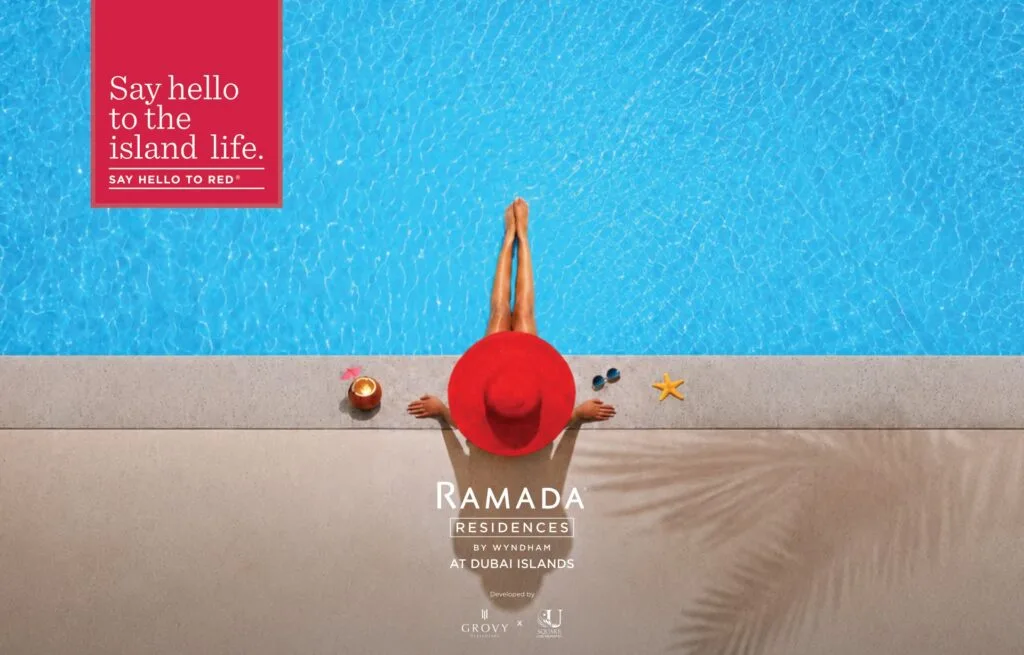 Person in red hat sitting at edge of blue swimming pool