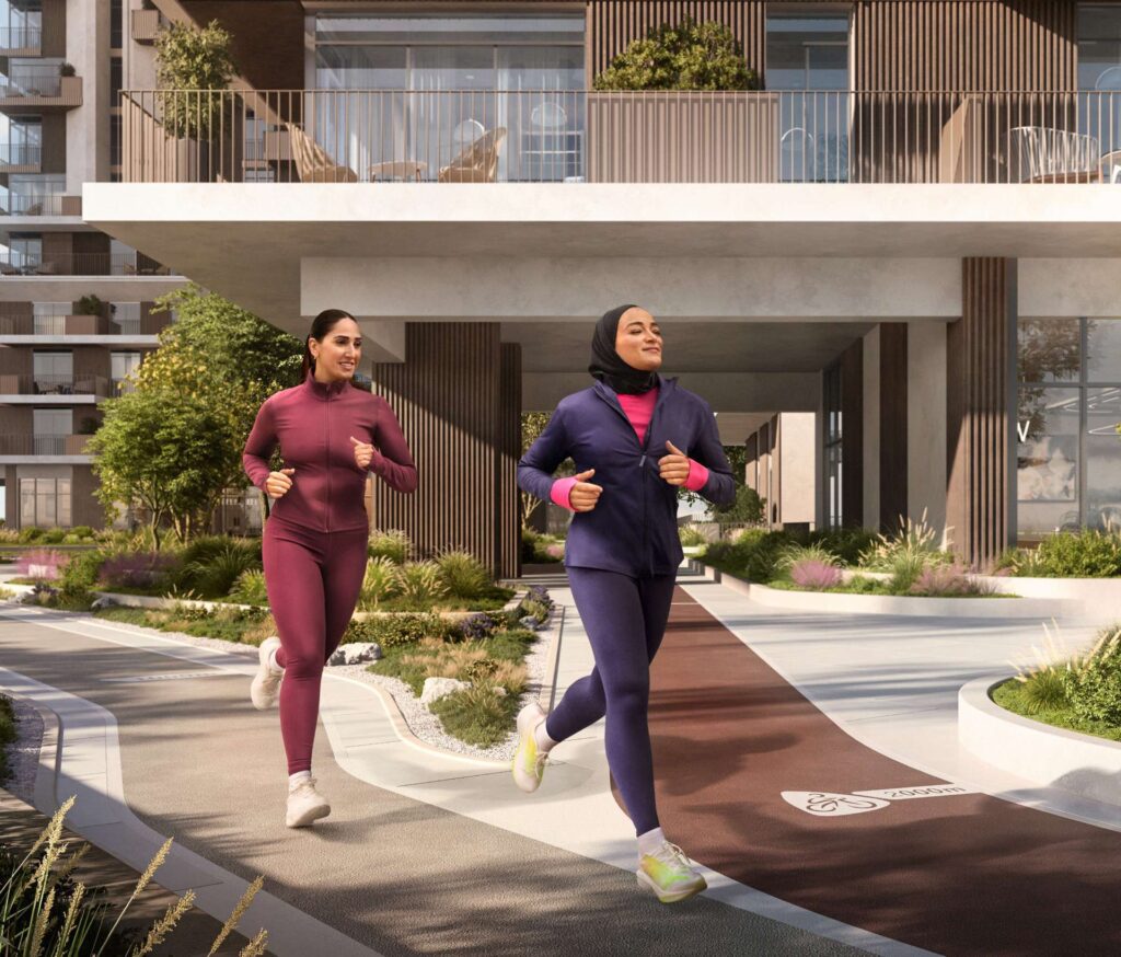 Two women jogging in front of modern residential buildings