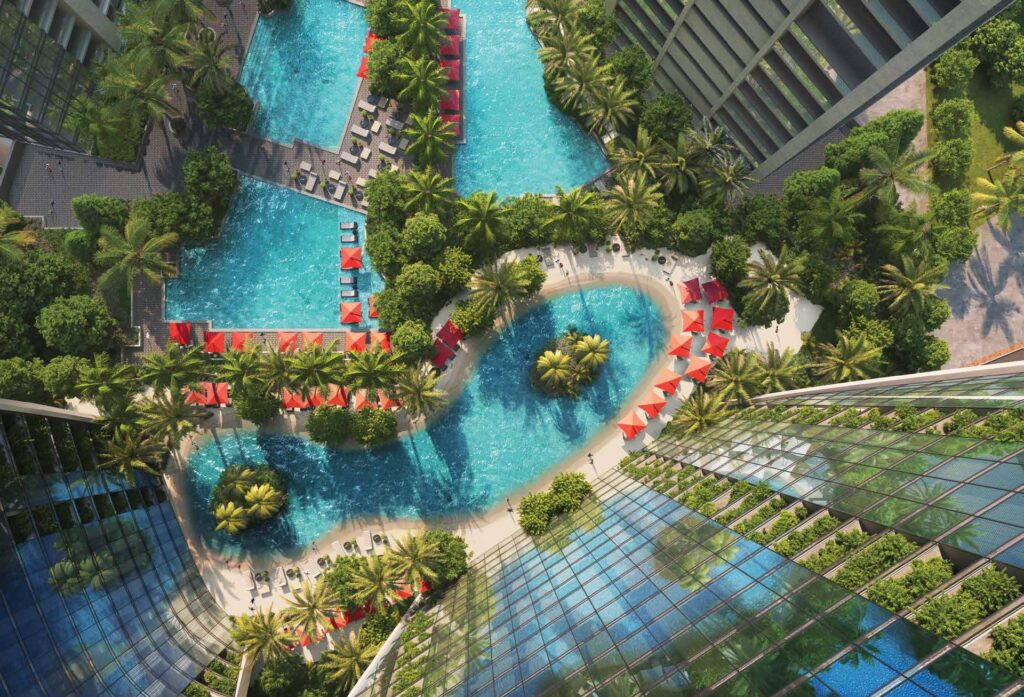 Aerial view of swimming pools surrounded by palm trees and buildings