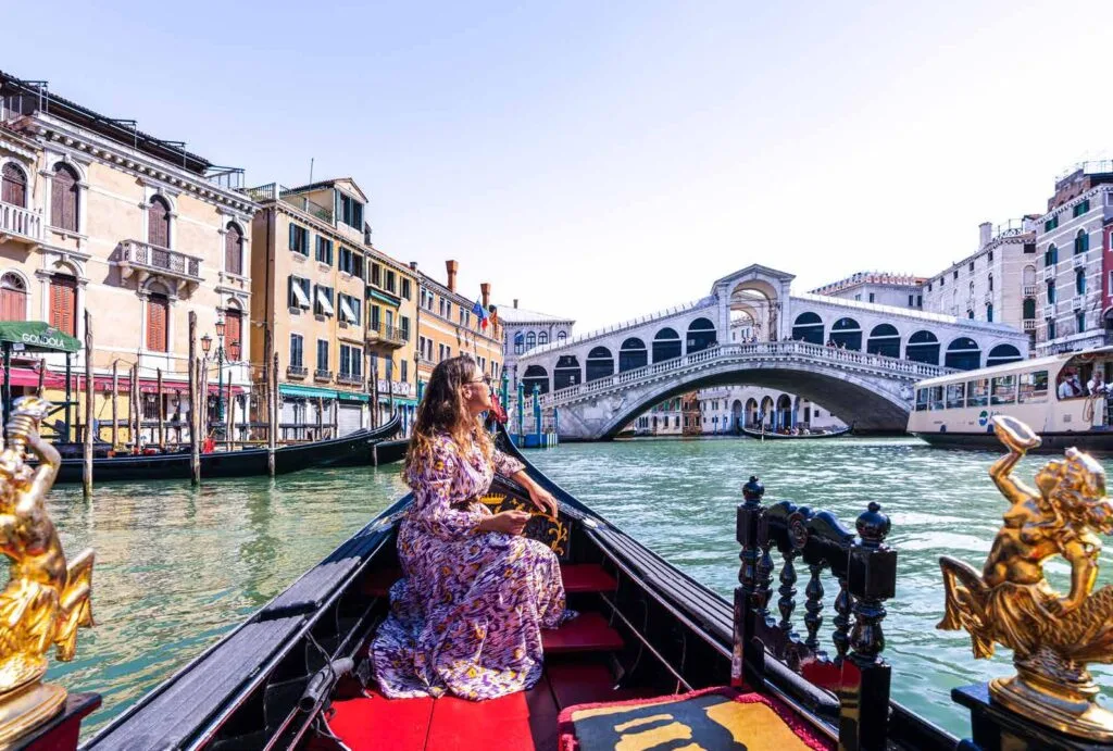 View from gondola on canal with bridge and buildings