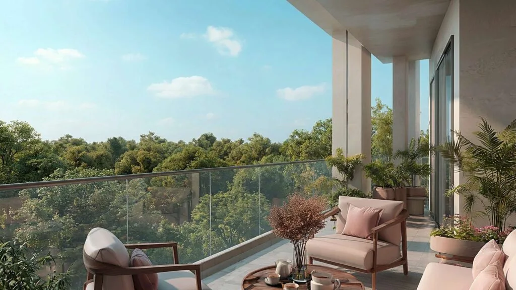 Balcony seating area overlooking green trees under blue sky
