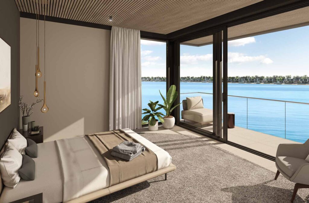 Bedroom interior with large glass doors opening to sea view balcony